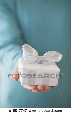 Stock Photo - USA, New Jersey, Jersey City, Man holding gift box in front of him. Fotosearch