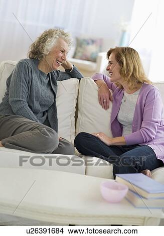 Picture - USA, New Jersey, Jersey City, Mother and daughter talking on sofa. Fotosearch