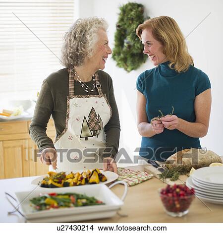 Picture - USA, New Jersey, Jersey City, Mother and daughter preparing food in kitchen. Fotosearch