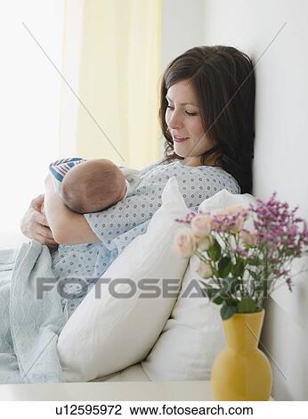 USA, New Jersey, Jersey City, Mother laying in bed with baby daughter (2-5 months) View Large Photo Image Stock Image - USA, New Jersey, Jersey City, Mother laying in bed with baby daughter (2-5 months). Fotosearch