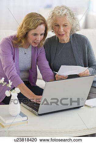 USA, New Jersey, Jersey City, Mother and daughter using laptop in living room View Large Photo Image Stock Image - USA, New Jersey, Jersey City, Mother and daughter using laptop in living room. Fotosearch