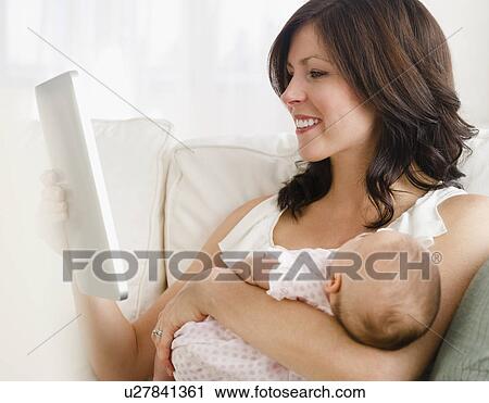 USA, New Jersey, Jersey City, Mother holding baby daughter (2-5 months), reading letter View Large Photo Image Stock Image - USA, New Jersey, Jersey City, Mother holding baby daughter (2-5 months), reading letter. Fotosearch