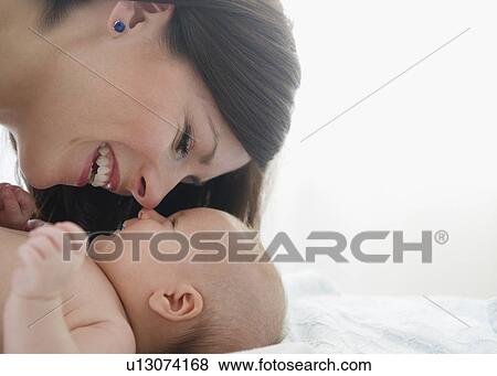 Stock Photo - USA, New Jersey, Jersey City, Mother laughing over baby girl (2-5 months). Fotosearch