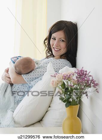 USA, New Jersey, Jersey City, Mother laying in bed with baby daughter (2-5 months) View Large Photo Image Stock Photograph - USA, New Jersey, Jersey City, Mother laying in bed with baby daughter (2-5 months). Fotosearch