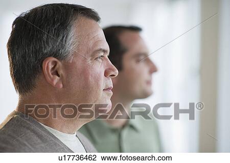 Stock Image - USA, New Jersey, Jersey City, Pensive man with son in background. Fotosearch