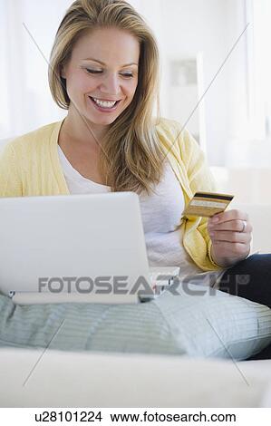 Picture - USA, New Jersey, Jersey City, Attractive young woman online shopping. Fotosearch
