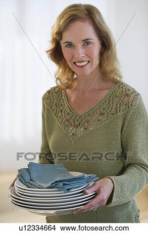 USA, New Jersey, Jersey City, Portrait of woman holding plates, smiling View Large Photo Image Picture - USA, New Jersey, Jersey City, Portrait of woman holding plates, smiling. Fotosearch