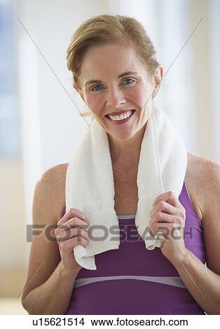 Picture - USA, New Jersey, Jersey City, Portrait of woman with towel at gym. Fotosearch