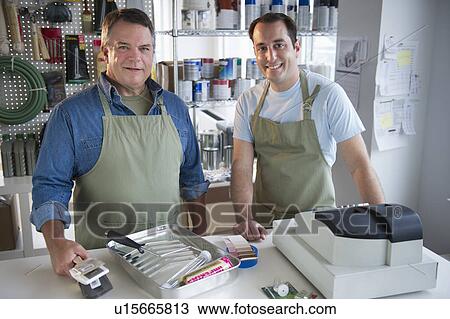 Stock Image - USA, New Jersey, Jersey City, Portrait of hardware shop owner and assistant. Fotosearch