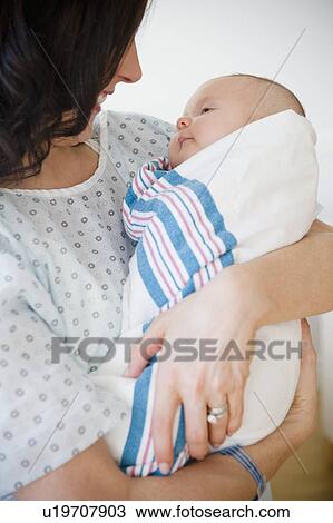 Stock Image - USA, New Jersey, Jersey City, Portrait of mother embracing baby girl (2-5 months). Fotosearch