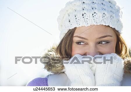 Stock Image - USA, New Jersey, Jersey City, Portrait of young woman wearing white knitted hat. Fotosearch
