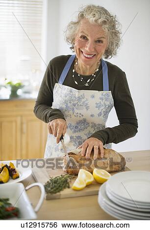 USA, New Jersey, Jersey City, Portrait of senior woman preparing food in kitchen View Large Photo Image Stock Photograph - USA, New Jersey, Jersey City, Portrait of senior woman preparing food in kitchen. Fotosearch