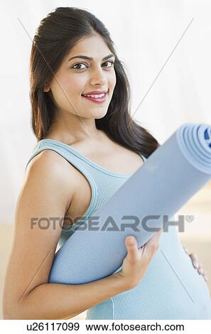 USA, New Jersey, Jersey City, Pregnant young attractive woman with exercising mat View Large Photo Image Stock Photo - USA, New Jersey, Jersey City, Pregnant young attractive woman with exercising mat. Fotosearch