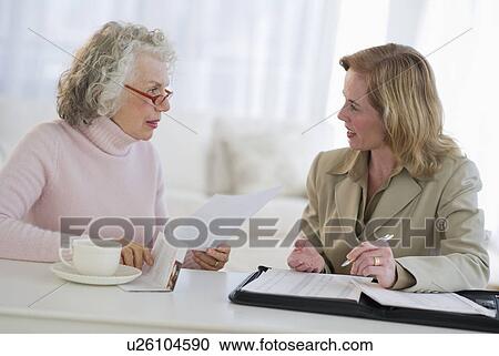 USA, New Jersey, Jersey City, Senior woman talking to financial advisor in home View Large Photo Image Stock Image - USA, New Jersey, Jersey City, Senior woman talking to financial advisor in home. Fotosearch
