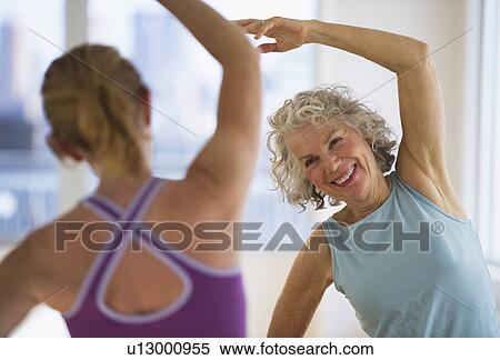 Stock Photography - USA, New Jersey, Jersey City, Senior woman with fitness instructor at gym. Fotosearch