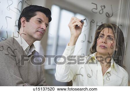 USA, New Jersey, Jersey City, Businessman and woman writing calculations on glass View Large Photo Image Stock Image - USA, New Jersey, Jersey City, Businessman and woman writing calculations on glass. Fotosearch
