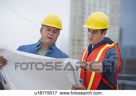 USA, New Jersey, Jersey City, Construction workers studying blueprints on construction site View Large Photo Image Stock Photo - USA, New Jersey, Jersey City, Construction workers studying blueprints on construction site. Fotosearch