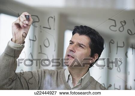 USA, New Jersey, Jersey City, Businessman writing calculations on glass View Large Photo Image Stock Photo - USA, New Jersey, Jersey City, Businessman writing calculations on glass. Fotosearch