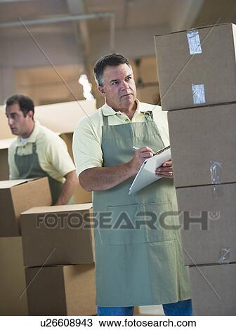 USA, New Jersey, Jersey City, Two male warehouse workers by stacked boxes View Large Photo Image Stock Image - USA, New Jersey, Jersey City, Two male warehouse workers by stacked boxes. Fotosearch