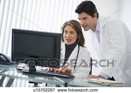 USA, New Jersey, Jersey City, Two doctors using computer in office View Large Photo Image Stock Photo - USA, New Jersey, Jersey City, Two doctors using computer in office. Fotosearch