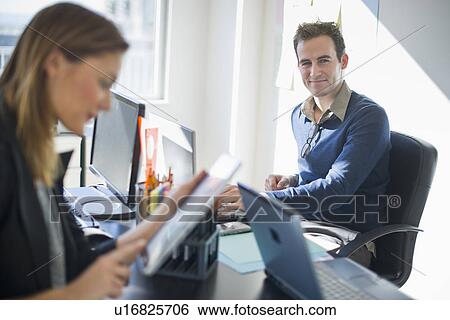 Stock Photograph - USA, New Jersey, Jersey City, Two young people in office. Fotosearch