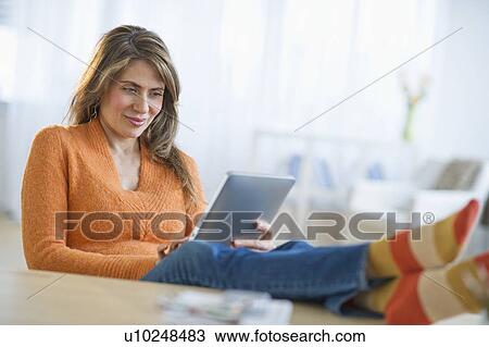 USA, New Jersey, Jersey City, Woman using digital tablet on sofa View Large Photo Image Stock Image - USA, New Jersey, Jersey City, Woman using digital tablet on sofa. Fotosearch