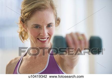 USA, New Jersey, Jersey City, Woman using hand weights at gym View Large Photo Image Stock Image - USA, New Jersey, Jersey City, Woman using hand weights at gym. Fotosearch