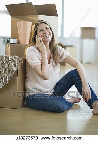 USA, New Jersey, Jersey City, Woman using mobile phone by boxes in new home View Large Photo Image Stock Photo - USA, New Jersey, Jersey City, Woman using mobile phone by boxes in new home. Fotosearch