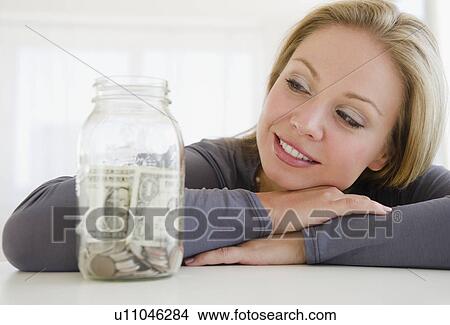 USA, New Jersey, Jersey City, Young attractive woman watching improvised jar - piggybank View Large Photo Image Picture - USA, New Jersey, Jersey City, Young attractive woman watching improvised jar - piggybank. Fotosearch