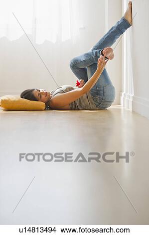 Picture - USA, New Jersey, Jersey City, Young attractive painting toenails. Fotosearch