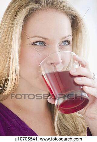 USA, New Jersey, Jersey City, Young attractive woman drinking juice View Large Photo Image Stock Image - USA, New Jersey, Jersey City, Young attractive woman drinking juice. Fotosearch