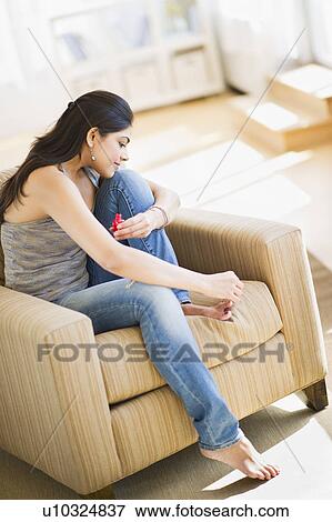Stock Photo - USA, New Jersey, Jersey City, Young attractive painting toenails. Fotosearch