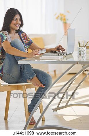 USA, New Jersey, Jersey City, Young Indian woman using laptop View Large Photo Image Stock Photo - USA, New Jersey, Jersey City, Young Indian woman using laptop. Fotosearch