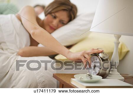 Stock Photo - USA, New Jersey, Jersey City, Young woman waking up. Fotosearch