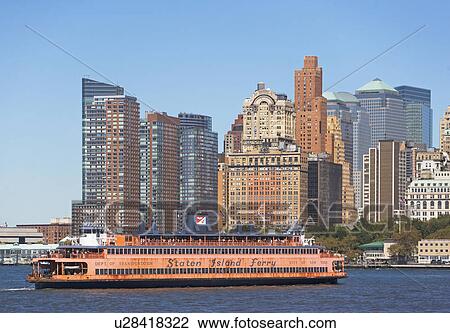 Stock Image - USA, New York City, Manhattan, Battery Park skyline with ferry. Fotosearch