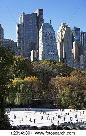 Stock Photo - USA, New York City, people ice skating in Central Park. Fotosearch