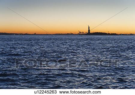 USA, New York City, Staten Island, Harbor and silhouette of Statue of Liberty in background View Large Photo Image Stock Image - USA, New York City, Staten Island, Harbor and silhouette of Statue of Liberty in background. Fotosearch