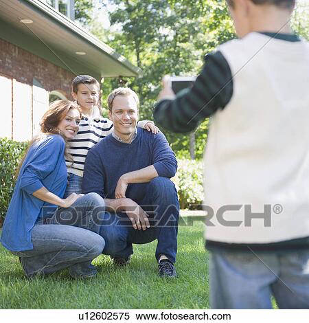 USA, New York, Flanders, Boy (4-5) taking photograph of mother, father and brother (8-9) View Large Photo Image Stock Photography - USA, New York, Flanders, Boy (4-5) taking photograph of mother, father and brother (8-9). Fotosearch
