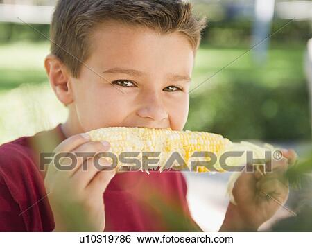 USA, New York, Flanders, Boy (8-9) eating corn View Large Photo Image Stock Photograph - USA, New York, Flanders, Boy (8-9) eating corn. Fotosearch