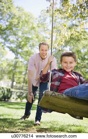 Picture - USA, New York, Flanders, Father and son (8-9) playing in garden. Fotosearch