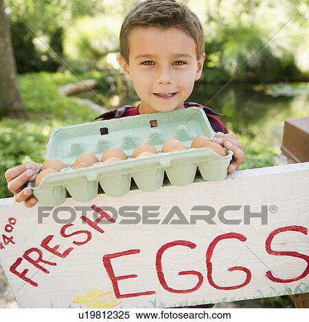 Stock Photography - USA, New York, Flanders, Mother and son (8-9) selling fresh eggs. Fotosearch