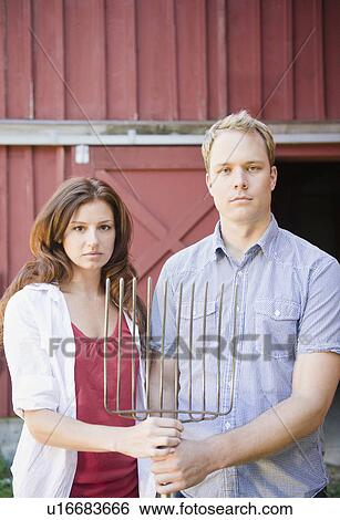 USA, New York, Flanders, Portrait of mid adult couple with pitchfork View Large Photo Image Stock Photograph - USA, New York, Flanders, Portrait of mid adult couple with pitchfork. Fotosearch