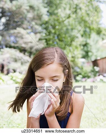 Stock Image - USA, New York, Girl (10-11) blowing nose. Fotosearch