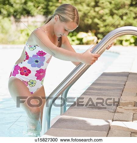 Stock Image - USA, New York, Girl (10-11) going into swimming pool. Fotosearch