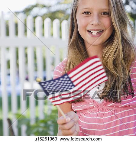 Stock Photo - USA, New York, Girl (10-11) holding American flag. Fotosearch