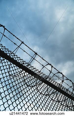 Stock Image - USA, New York, New York City, Barbed wire fence. Fotosearch