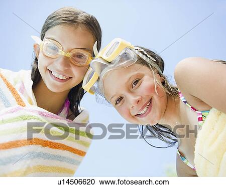 Stock Image - USA, New York, Two girls (10-11, 10-11) wearing swimming goggles. Fotosearch