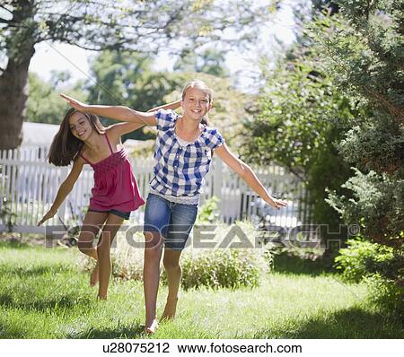 Stock Image - USA, New York, Two girls (10-11, 10-11) playing in backyard. Fotosearch