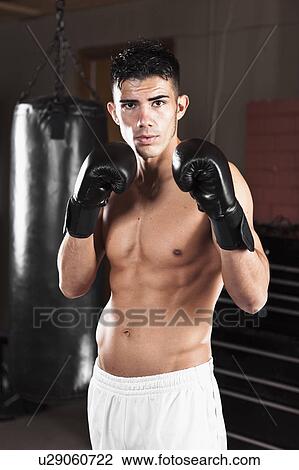 USA, Seattle, Portrait of young man in gym wearing boxing gloves View Large Photo Image Stock Image - USA, Seattle, Portrait of young man in gym wearing boxing gloves. Fotosearch