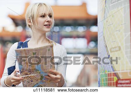 USA, Seattle, Smiling young woman holding map View Large Photo Image Stock Image - USA, Seattle, Smiling young woman holding map. Fotosearch